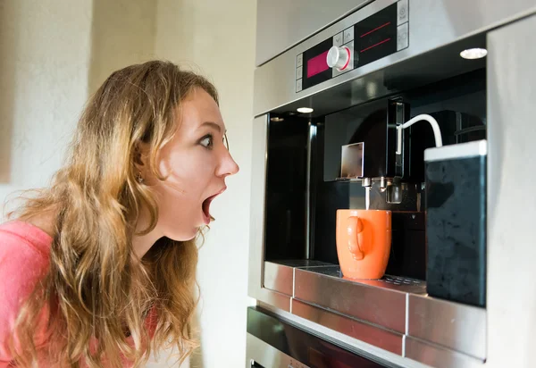 Choque mulher fazendo xícara de café máquina cozinha interior — Fotografia de Stock