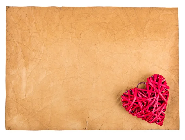 Red straw hearts on old paper — Stock Photo, Image