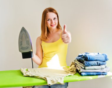 genç güzel kadın giysi odasında Ütü