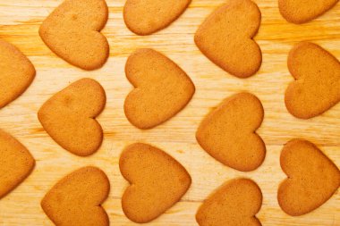 Çerezler ahşap masa arka plan üzerinde kalp şeklinde