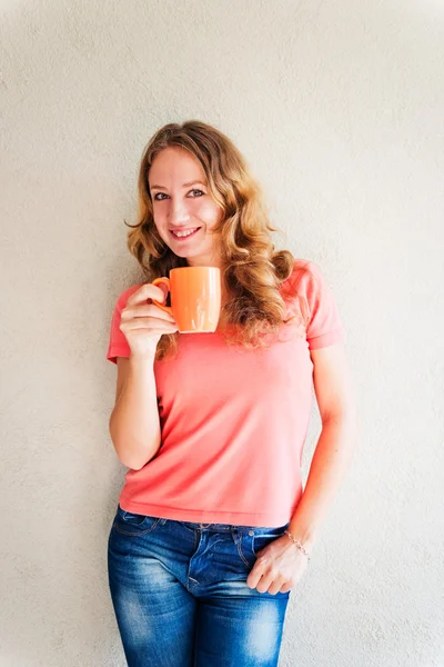 Krásná a usmívající se žena s šálkem kávy — Stock fotografie