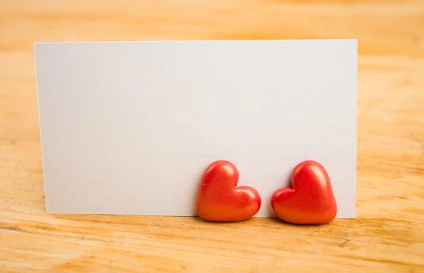 Red hearts and note on wooden background — Stock Photo, Image