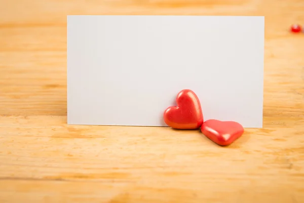 Corazones rojos y nota sobre fondo de madera — Foto de Stock