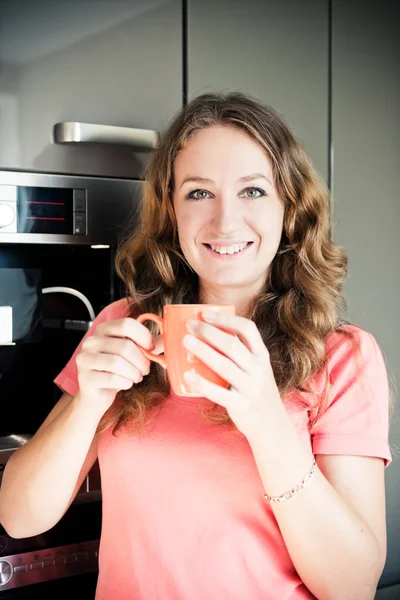 Vacker glad ung kvinna dricker kaffe hemma i morgonen — Stockfoto