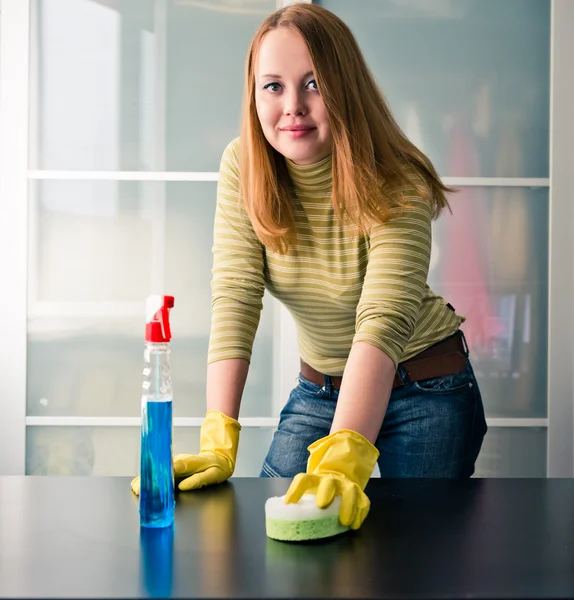 Glad tjej rengöring bord med möbler polska hemma — Stockfoto