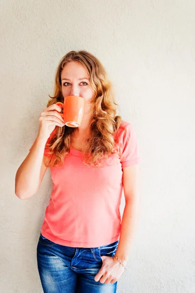 Schöne und lächelnde Frau mit einer Tasse Kaffee — Stockfoto