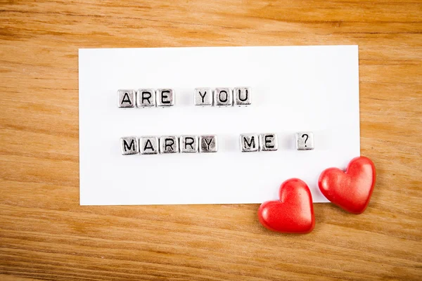 Сердца и записка "Ты женишься на мне ?" — стоковое фото