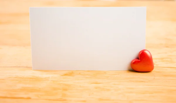 Corazones rojos y nota sobre fondo de madera —  Fotos de Stock