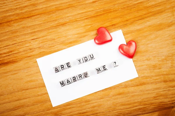 Hearts and note "Are you marry me?" — Stock Photo, Image