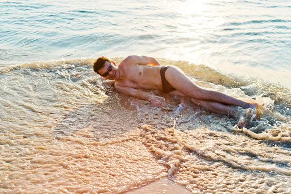 Uomo godendo in acqua sulla spiaggia — Foto Stock