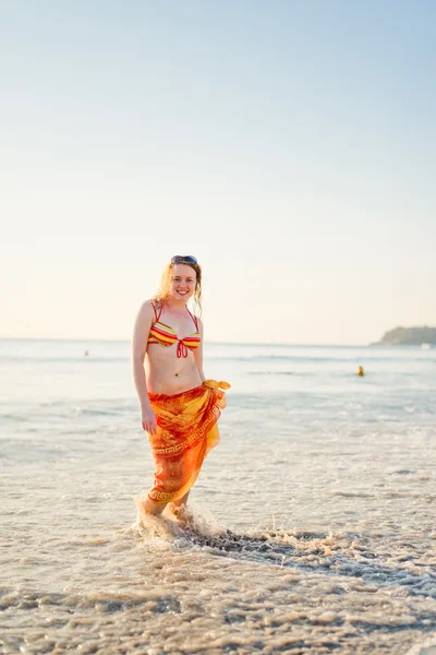 Jovem mulher sorrindo se divertindo em pé na água do mar — Fotografia de Stock