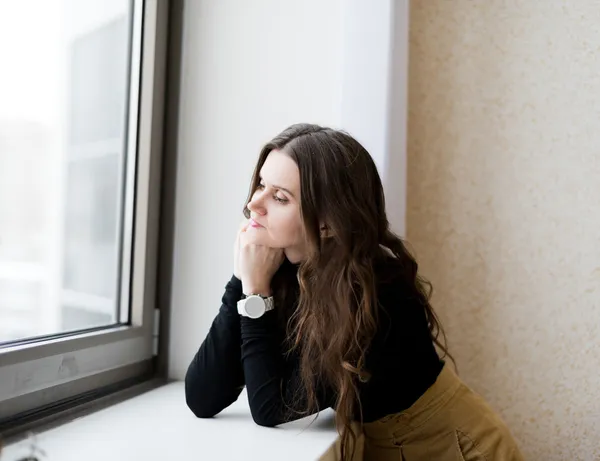 Attractive young adult looking at the window — Stock Photo, Image
