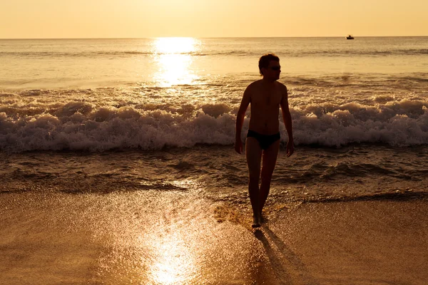 Man på stranden vid solnedgången — Stockfoto