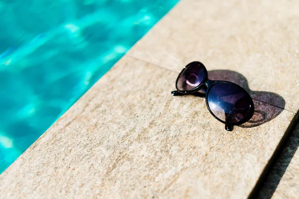 Sunglasses near swimming pool — Stock Photo, Image