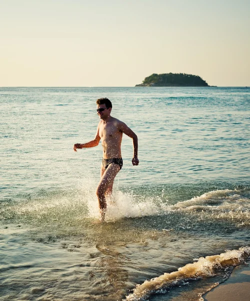 熱帯の海の水で男を実行します。 — ストック写真