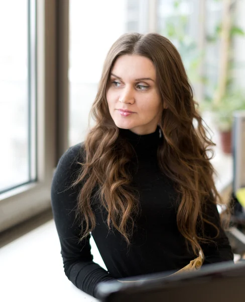 Beautiful woman looking away near window — Stock Photo, Image