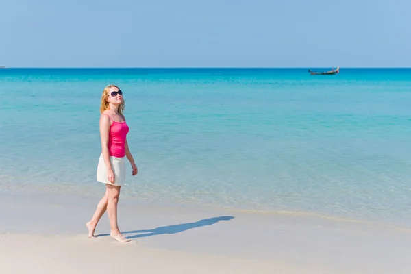 Vrouw in roze top wandelen op het strand — Stockfoto