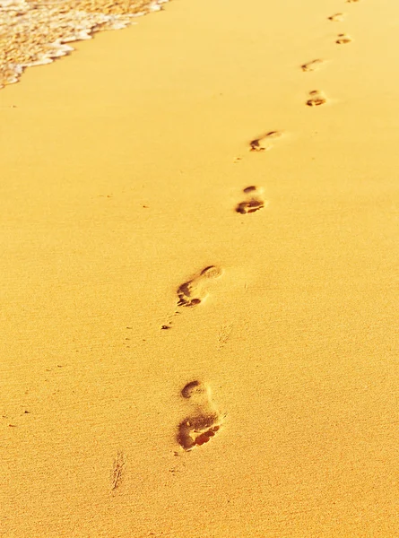 Stopy v písku s vlnami — Stock fotografie