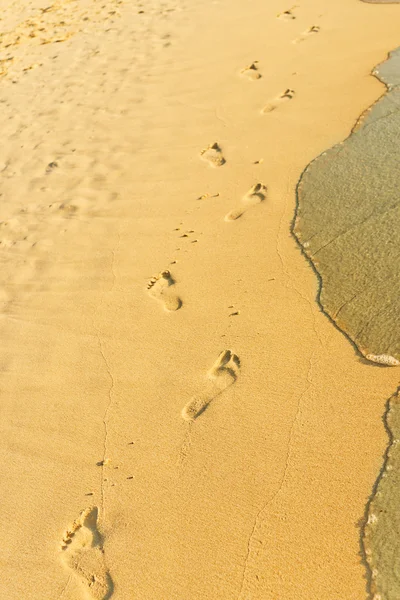 Fotavtryck på sand med vågor — Stockfoto