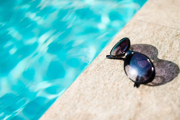 Sunglasses near swimming pool — Stock Photo, Image