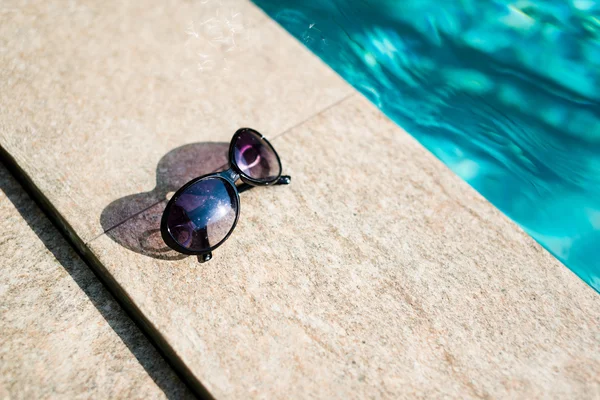 Sunglasses near swimming pool — Stock Photo, Image