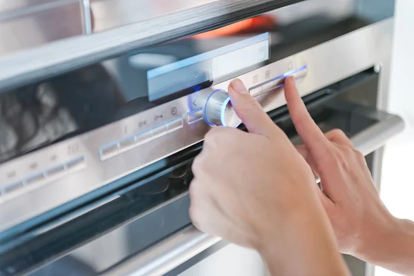 Mão movendo o botão temporizador no forno — Fotografia de Stock