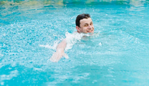 Hombre joven nadando en la piscina Fotos de stock libres de derechos