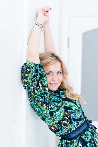 Beautiful woman posing near white wall — Stock Photo, Image