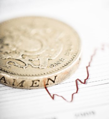 bir İngiliz Lirası para dalgalanan grafik üzerinde.