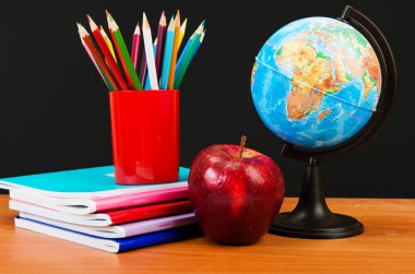 Küre, yığın defter ve kalemler.