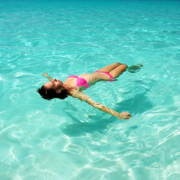 Vrouw in bikini liggend op water — Stockfoto