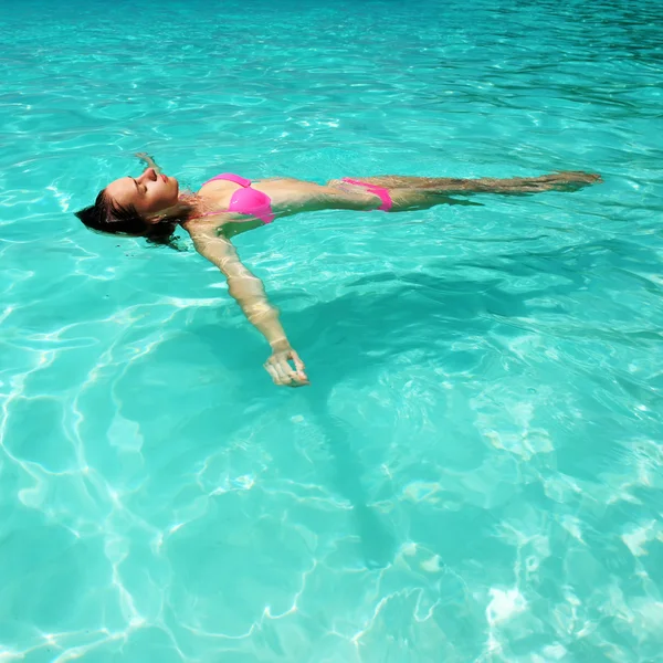Vrouw in bikini liggend op water — Stockfoto