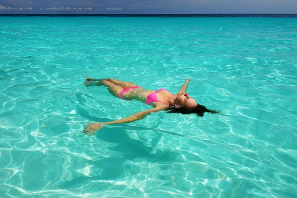 Vrouw in bikini liggend op water — Stockfoto