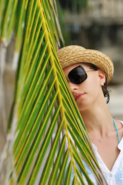 Femme en lunettes de soleil près de palmier — Photo