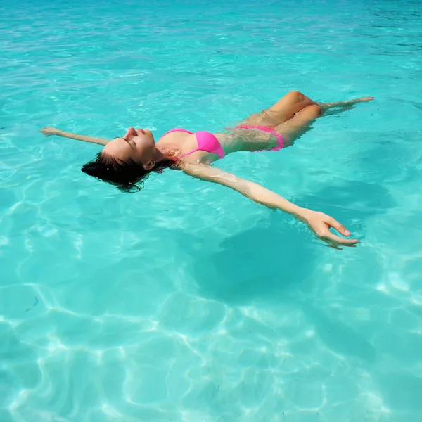 Vrouw in bikini liggend op water — Stockfoto