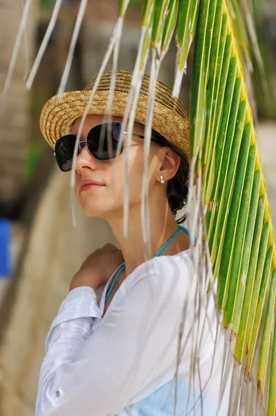 Женщина в солнечных очках возле пальмы — стоковое фото