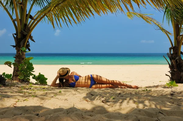 Kvinna på stranden under palmträd — Stockfoto