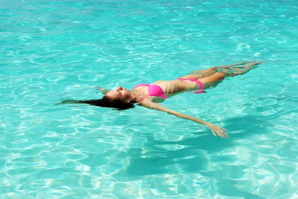 Frau im Bikini liegt auf dem Wasser — Stockfoto