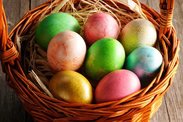 Colored easter eggs in basket — Stock Photo, Image