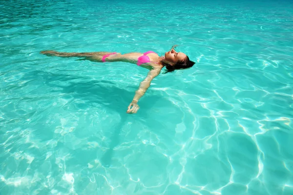 Frau im Bikini liegt auf dem Wasser — Stockfoto