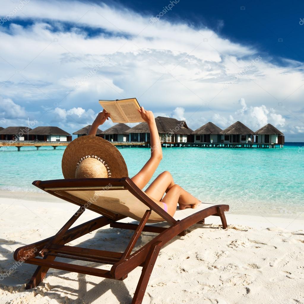 Young woman reading a book at beach