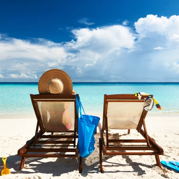 Mujer en una playa tropical en chaise lounge — Foto de Stock