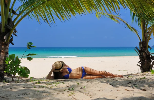 Vrouw aan het strand onder palmboom — Stockfoto
