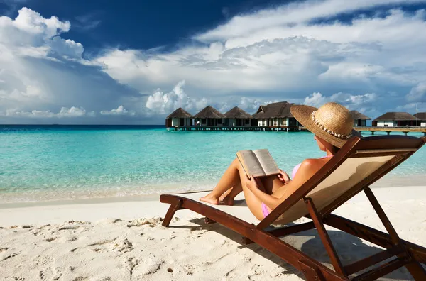 Young woman reading a book at beach — Stock Photo, Image