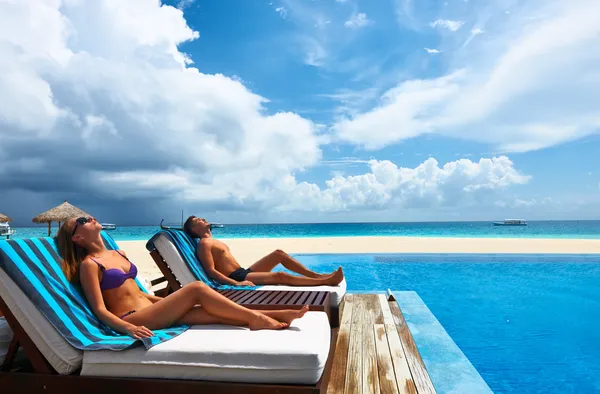 Casal relaxante à beira da piscina — Fotografia de Stock