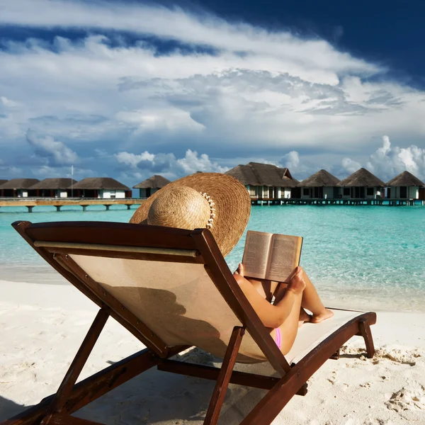 Mujer joven leyendo un libro en la playa —  Fotos de Stock