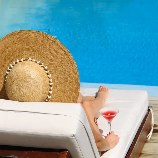 Femme au bord de la piscine avec cocktail cosmopolite — Photo