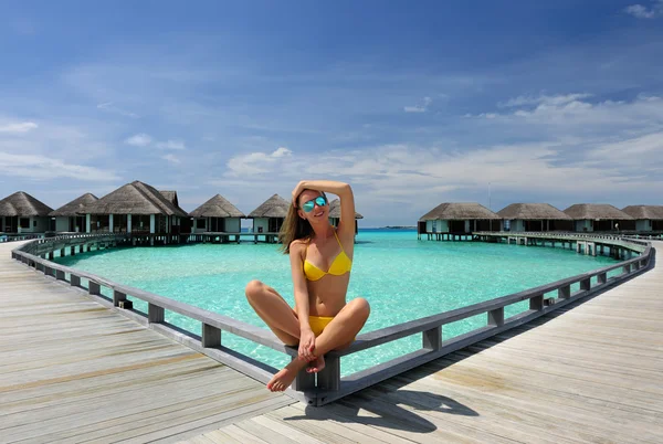 Žena na pláži molo na Maledivy — Stock fotografie