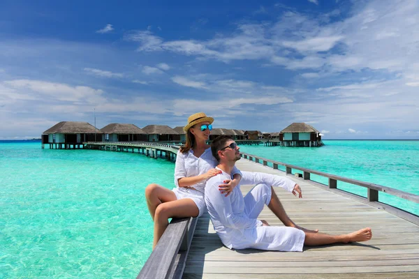 Casal em um molhe de praia em Maldivas — Fotografia de Stock