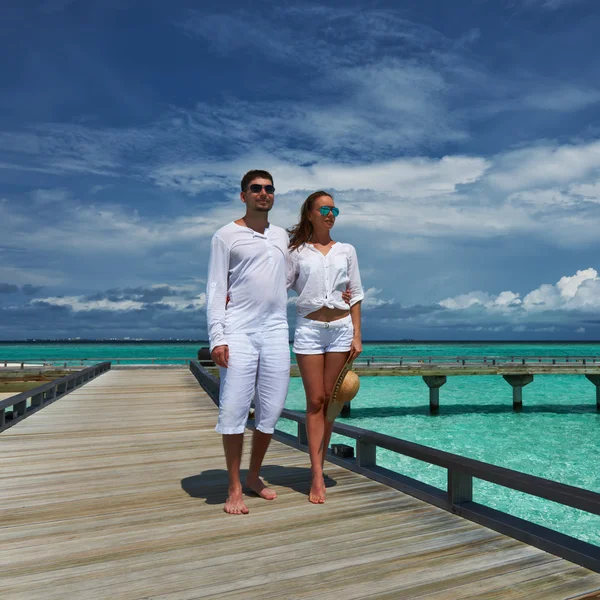 Casal em um molhe de praia em Maldivas — Fotografia de Stock